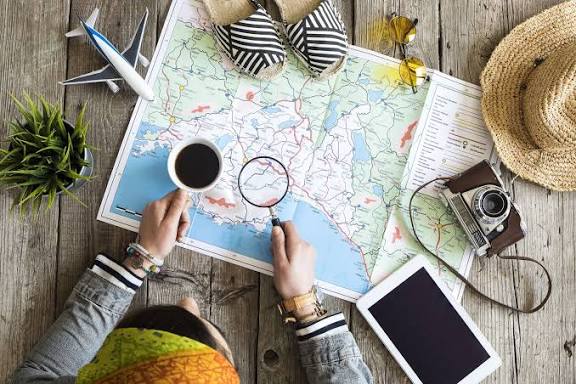 Traveler planning a vacation with a map, coffee, camera, and passport essentials