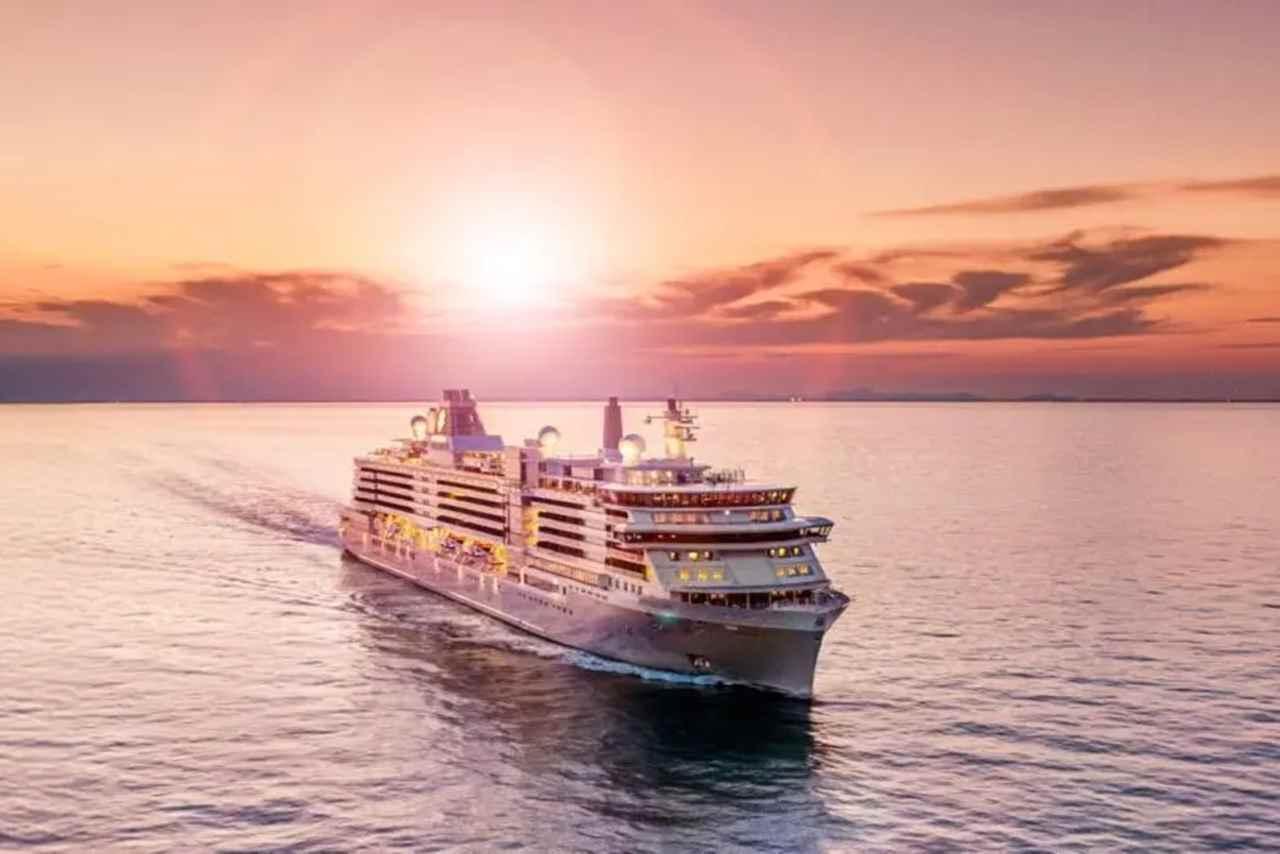 Cruise ship sailing at sunset on calm ocean water